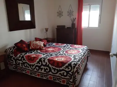 a bedroom with a bed with a black and red blanket at La Perla de Cádiz by Gades Gestión in Cádiz