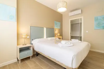 a bedroom with two beds with towels on them at Allo Apartments Europa II Parking Piscina Padel 4 Habitaciones in Jerez de la Frontera