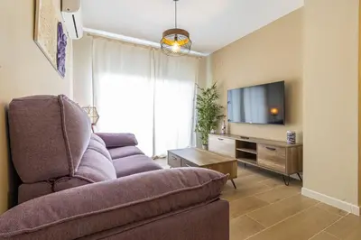a living room with a couch and a tv at Allo Apartments Europa II Parking Piscina Padel 4 Habitaciones in Jerez de la Frontera