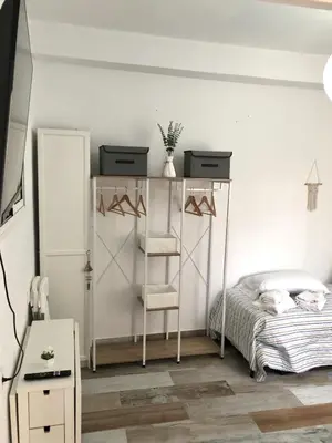 a bedroom with a bed and a shelf with hangers at Céntrico Rota Beach. in Rota