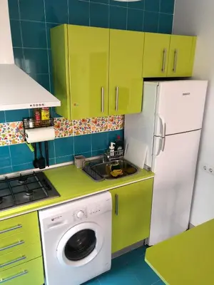 a kitchen with green cabinets and a washing machine at Céntrico Rota Beach. in Rota