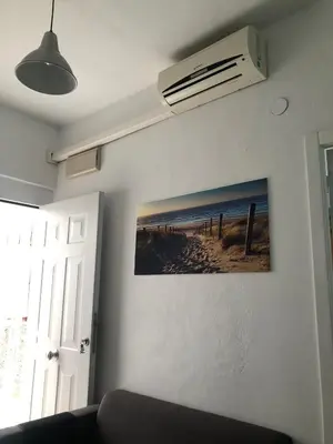 a room with a couch and a picture of a beach at Céntrico Rota Beach. in Rota