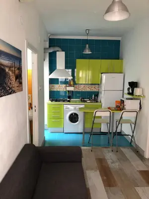 a kitchen with green cabinets and a table with chairs at Céntrico Rota Beach. in Rota
