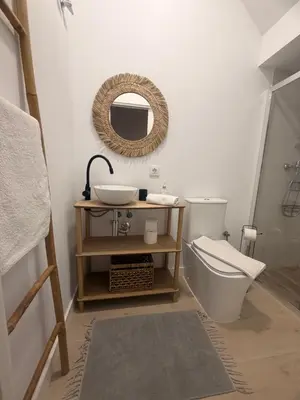 a bathroom with a sink and a toilet and a mirror at Apartamentos Corredera 2 in Arcos de la Frontera