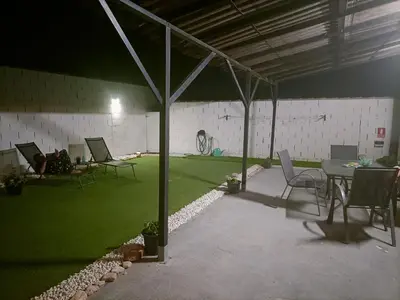 a patio with a table and chairs and green grass at Casa, Sueños del Sur in Chiclana de la Frontera