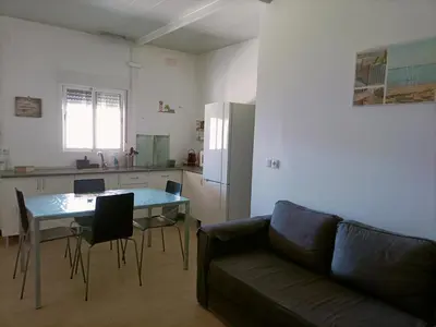 a living room with a couch and a table and a kitchen at Casa, Sueños del Sur in Chiclana de la Frontera