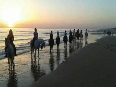 a group of people riding horses on the beach at Casa, Sueños del Sur in Chiclana de la Frontera