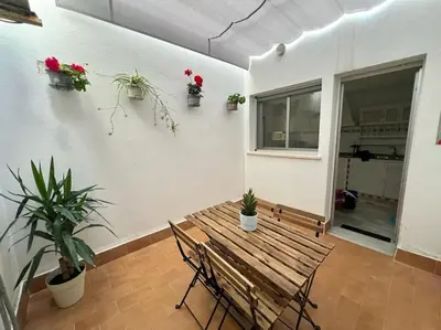 a wooden table and chairs in a room with potted plants at pleno centro con garaje , san Jorge in Sanlúcar de Barrameda