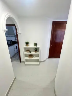 a white room with a door and a table with plants at pleno centro con garaje , san Jorge in Sanlúcar de Barrameda