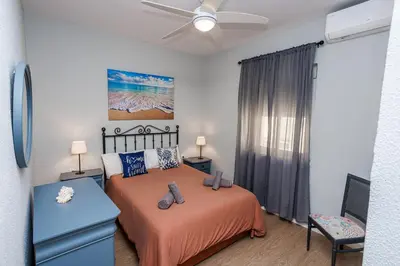 a bedroom with a bed and a ceiling fan at Apartamento Playa Santa María del Mar in Cádiz