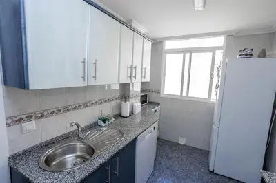 a kitchen with a sink and a refrigerator at Apartamento Playa Santa María del Mar in Cádiz