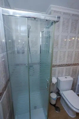 a bathroom with a glass shower with a toilet at Apartamento Playa Santa María del Mar in Cádiz