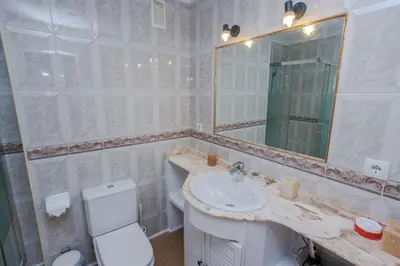a bathroom with a sink and a toilet and a mirror at Apartamento Playa Santa María del Mar in Cádiz
