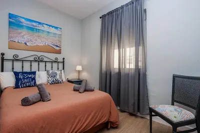 a bedroom with a bed and a window at Apartamento Playa Santa María del Mar in Cádiz