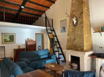 a living room with a blue couch and a fireplace at Casa Rural Los Murtales in Alcalá de los Gazules