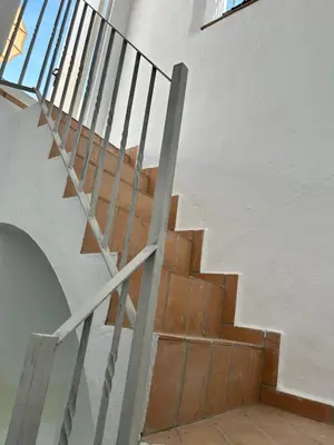 a staircase in a building with a metal railing at ESTUDIO CON TERRAZA CHILL in El Puerto de Santa María