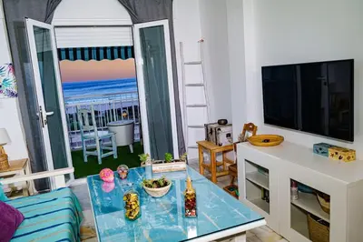 a living room with a table and a view of the ocean at Apartamento con inmejorables vistas de la Barrosa in Chiclana de la Frontera