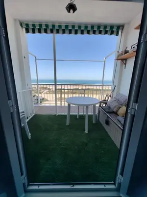 a balcony with a table and a view of the ocean at Apartamento con inmejorables vistas de la Barrosa in Chiclana de la Frontera