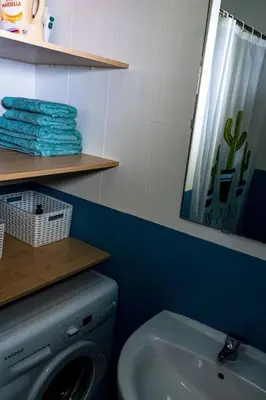 a bathroom with a washing machine and a sink at Apartamento con inmejorables vistas de la Barrosa in Chiclana de la Frontera