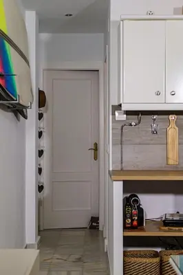 a kitchen with a white door and a hallway with a door at Apartamento con inmejorables vistas de la Barrosa in Chiclana de la Frontera