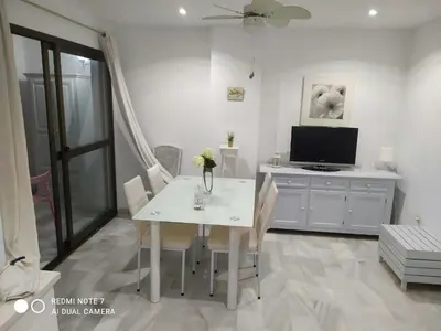a room with a table and a cabinet and a window at Vistahermosa Gestur Apartamentos in El Puerto de Santa María