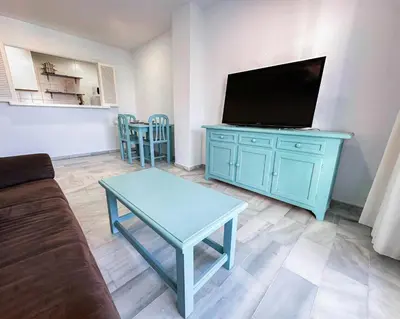 a living room with a blue cabinet with a flat screen tv at Vistahermosa Gestur Apartamentos in El Puerto de Santa María