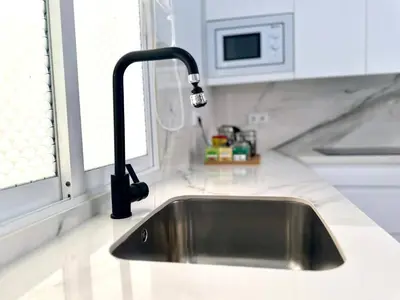 a kitchen sink with a black faucet next to a window at Apartment in Plaza Arenal in Jerez de la Frontera