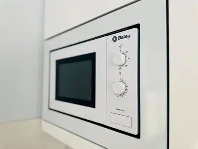 a microwave oven with a tv on a wall at Apartment in Plaza Arenal in Jerez de la Frontera