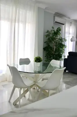 a dining room with a glass table and white chairs at Apartment in Plaza Arenal in Jerez de la Frontera