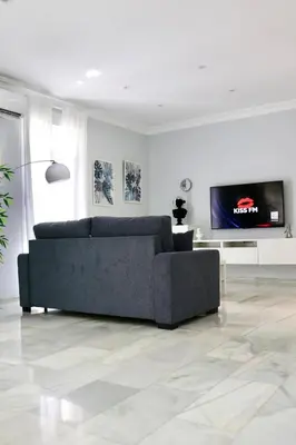 a living room with a couch and a flat screen tv at Apartment in Plaza Arenal in Jerez de la Frontera