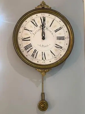a gold clock hanging on a white wall at Villa La Calma in El Puerto de Santa María