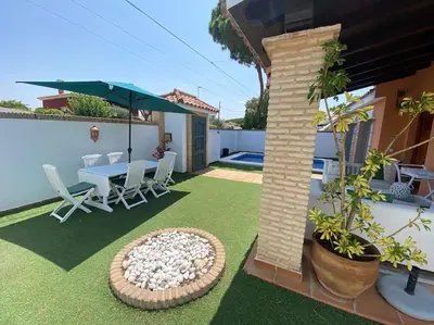 a patio with a table and chairs and an umbrella at Villa La Calma in El Puerto de Santa María