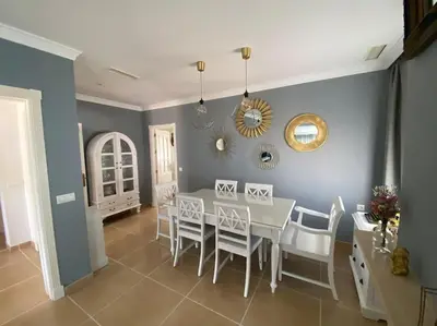 a dining room with a white table and chairs at Villa La Calma in El Puerto de Santa María