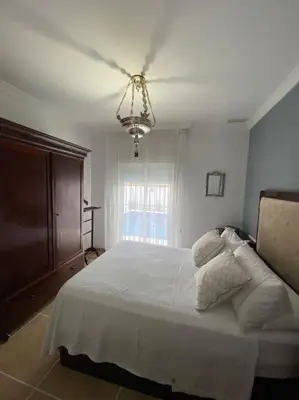 a bedroom with a white bed with a ceiling fan at Villa La Calma in El Puerto de Santa María