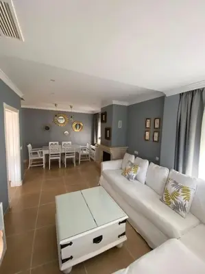 a living room with a white couch and a table at Villa La Calma in El Puerto de Santa María