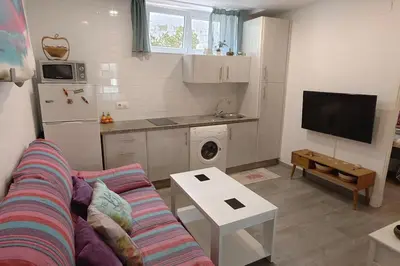 a living room with a couch and a kitchen at Apartamento a pie de playa. in Chiclana de la Frontera
