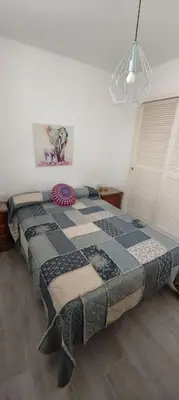 a bedroom with a bed with a quilt on it at Apartamento a pie de playa. in Chiclana de la Frontera