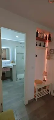 a room with a bathroom with a sink and a table at Apartamento a pie de playa. in Chiclana de la Frontera