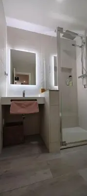 a bathroom with a shower and a sink and a mirror at Apartamento a pie de playa. in Chiclana de la Frontera