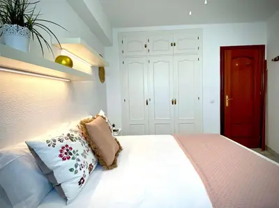 a bedroom with a bed with pillows and a red door at MyChoice Pitiusa in Rota