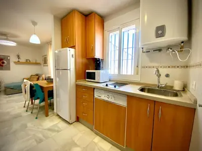 a kitchen with a sink and a refrigerator and a table at MyChoice Pitiusa in Rota