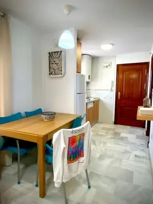 a kitchen with a wooden table and blue chairs at MyChoice Pitiusa in Rota