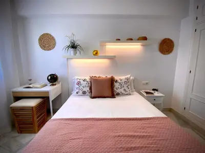 a bedroom with a large bed with a pink blanket at MyChoice Pitiusa in Rota