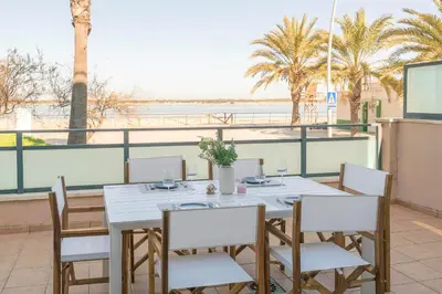 a table and chairs with a view of the ocean at Atardecer en Sanlúcar in Sanlúcar de Barrameda