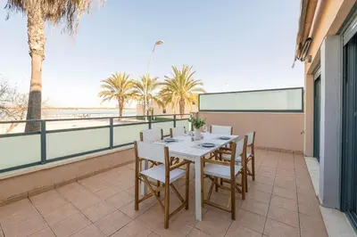 a table and chairs on a balcony with palm trees at Atardecer en Sanlúcar in Sanlúcar de Barrameda