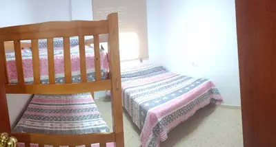 a bedroom with a bed with a quilt on it at Apartamento El Niño de Oro in Sanlúcar de Barrameda