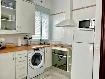 a kitchen with a white refrigerator and a dishwasher at Alojanómadas Jerez Centro in Jerez de la Frontera