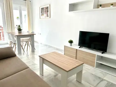 a white living room with a flat screen tv at Alojanómadas Jerez Centro in Jerez de la Frontera