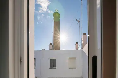 a view from a window of a building with a tower at El Paseo del Faro in Chipiona