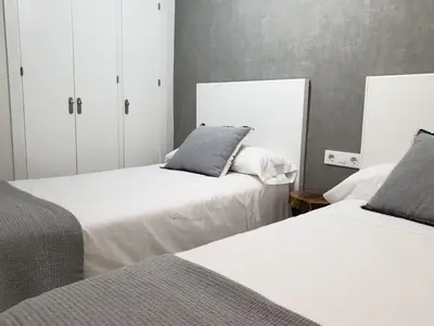 two beds sitting next to each other in a bedroom at Las Antillas by RentCadiz in El Puerto de Santa María